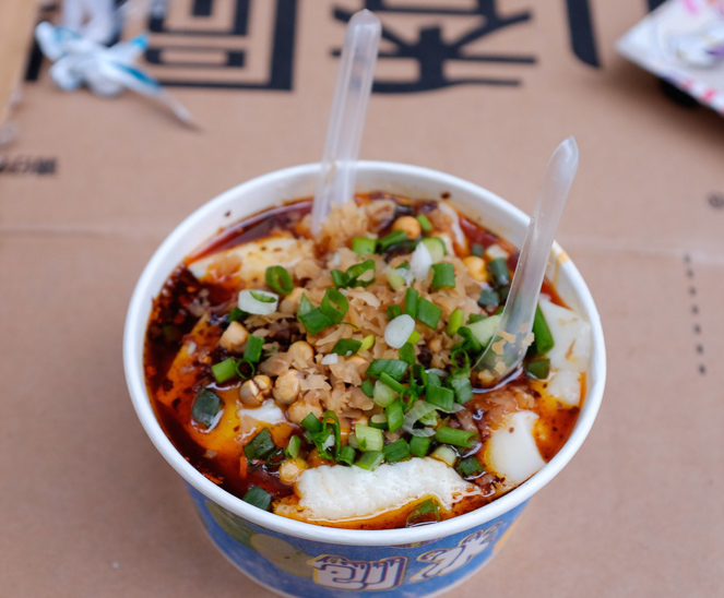 On the streets of Chengdu - fresh, warm tofu with soy sauce, chile oil, Sichuan peppercorns, peanuts, scallions, and probably all sorts of other deliciousness.
