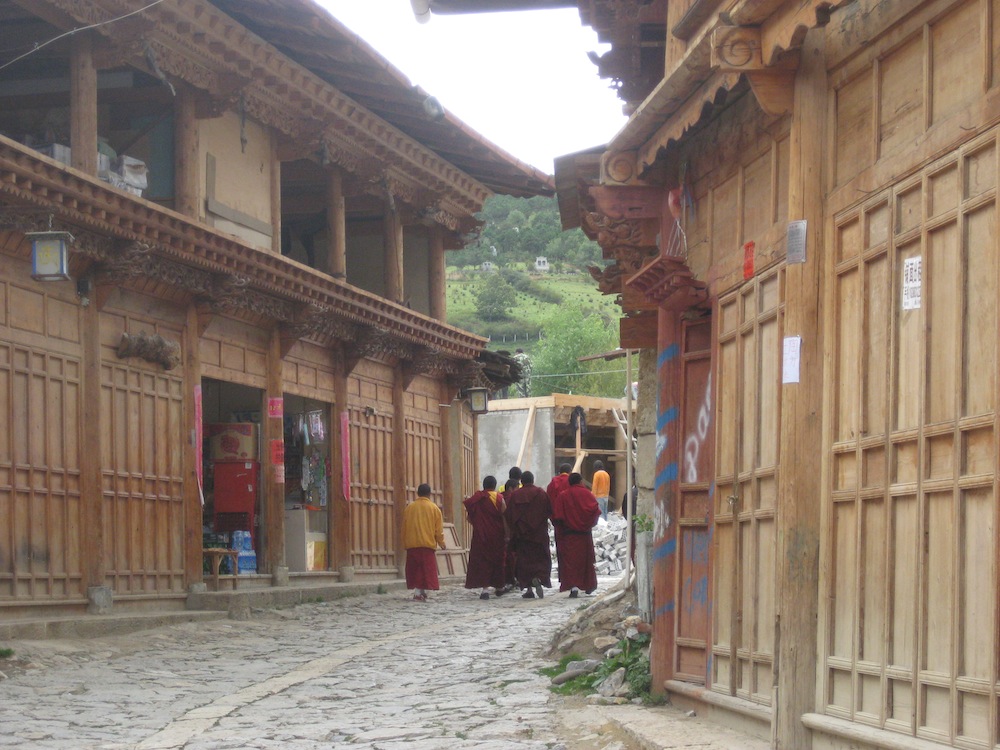 Young monks stroll down a street of new "traditional" houses in Old Town